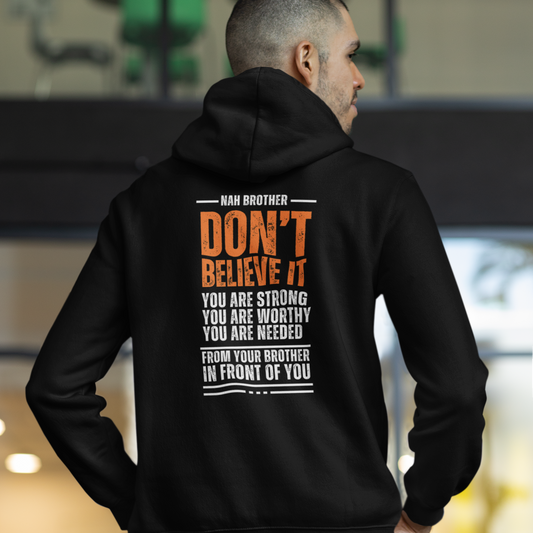 Person wearing a black hoodie with motivational text on the back, standing in an indoor setting.