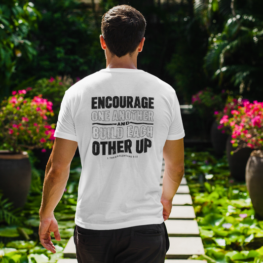 Person wearing a white t-shirt with motivational text in a garden setting