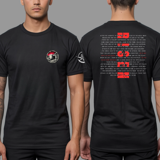 Black t-shirt with graphic design on front and text on back, worn by a person.