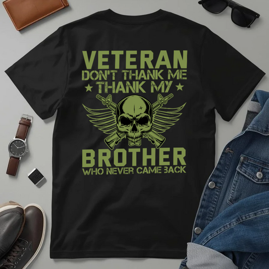 Black t-shirt with green text and graphic, surrounded by accessories on a gray background