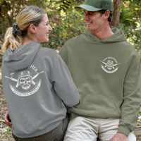 Two people sitting on a log in a forest wearing branded hoodies.