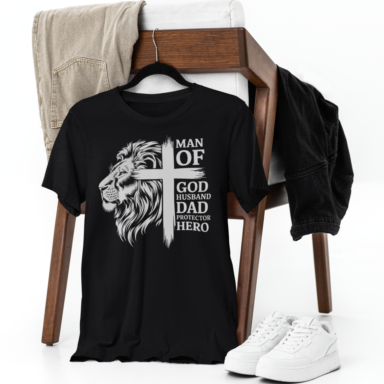 Black t-shirt with a lion graphic and text on a chair with jeans and sneakers.
