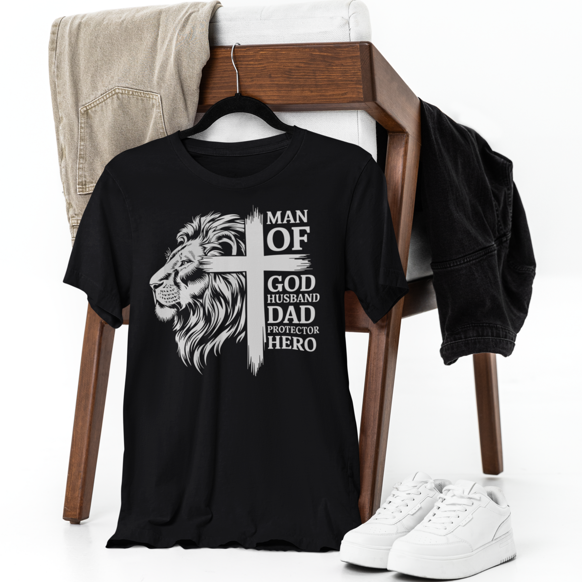 Black t-shirt with a lion graphic and text on a chair with jeans and sneakers.