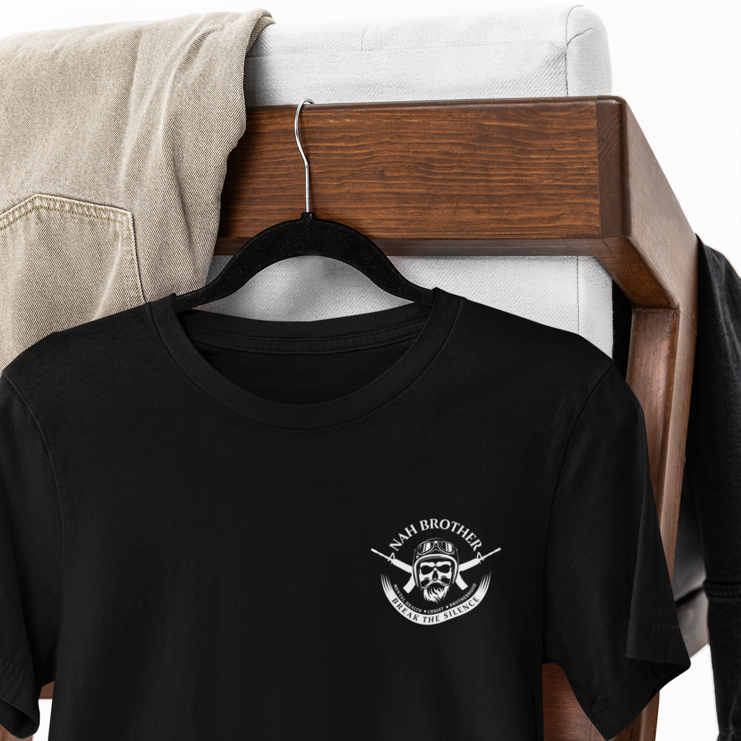Black t-shirt with a logo on a wooden hanger against a white background
