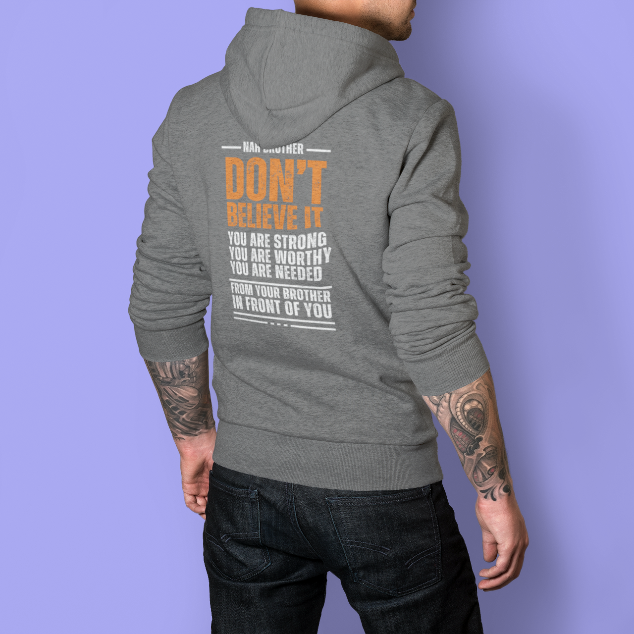 Person wearing a gray hoodie with motivational text on the back against a purple background