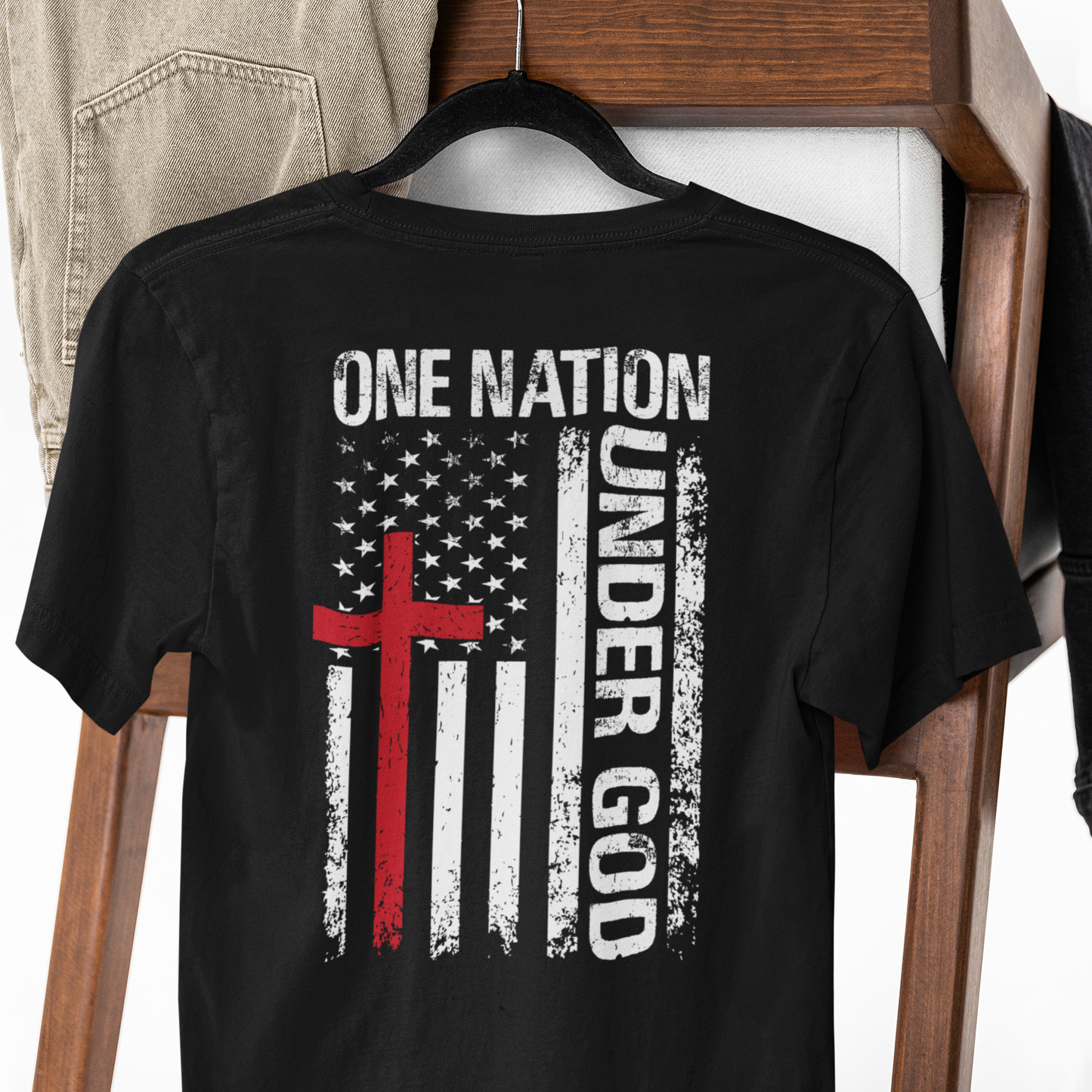 Black t-shirt with American flag design and 'One Nation Under God' text on a wooden rack.